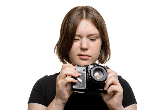Young woman looking closely at her camera adjusting settings, isolated on transparent background. - Powered by Adobe
