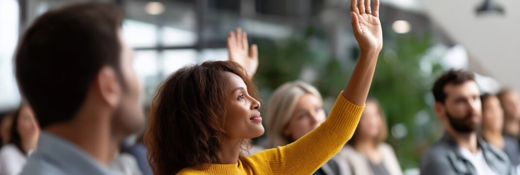 Diverse audience engaged in seminar with raised hands