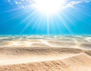Sun rays stream through the clear ocean illuminating sandy seabed