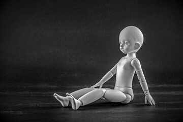 Doll sitting on a dark background