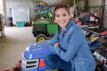 woman sitting on a mowing tractor © auremar