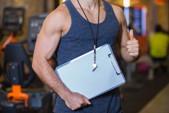 close-up of trainer showing his thumbs up at gym