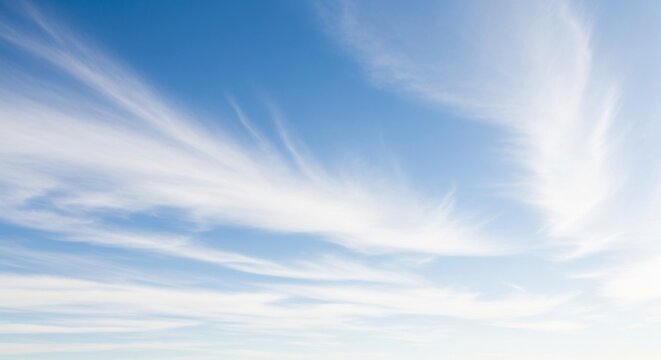 Fototapeta Wispy white clouds against clear blue sky on a sunny day