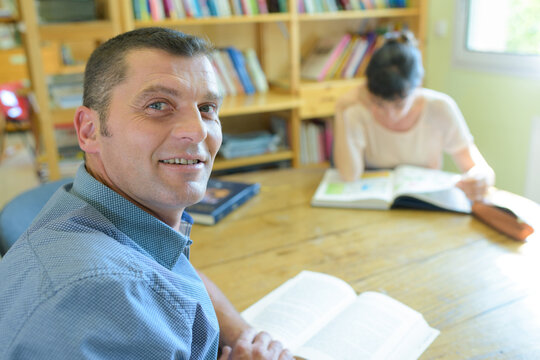 mature male student studying in library - Powered by Adobe