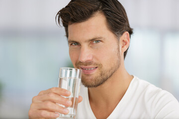 man going to drink water from the glass