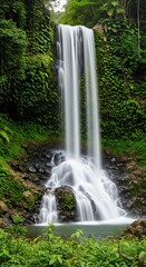 Fototapeta premium Stunning Tropical Waterfall Cascading Down Lush Green Cliffside in a Serene Jungle Landscape.