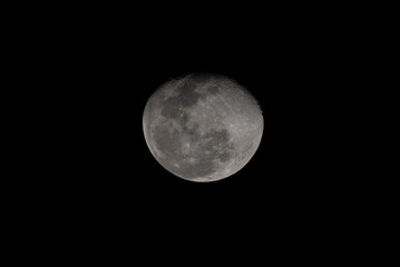 Close-up photo of the bright moon at night, showing detailed craters and lunar surface texture against a dark black sky. Perfect for astronomy, science, and nature themes.