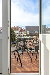 Open Door to Cozy Balcony with Wine and City View