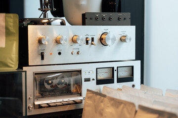 Vintage audio equipment with recording tapes and various controls on display in a cozy setting