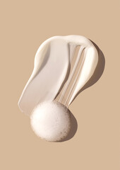 cosmetic smears of creamy texture on a beige background