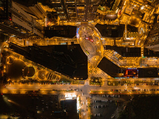 Aerial view of a modern city illuminated by warm streetlights, showing a geometric network of roads and buildings, Golf Course Extension Road, Gurugram, Haryana, India.