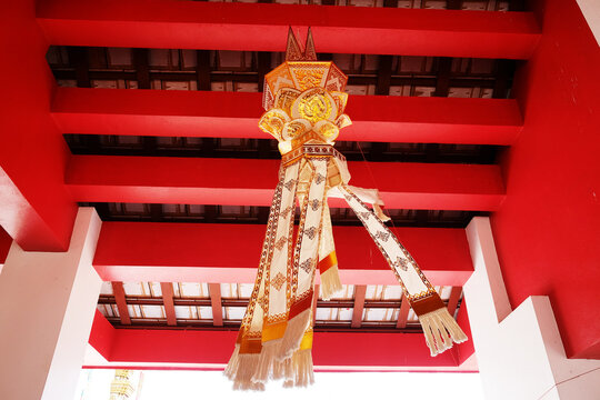 Beautiful handmade culture golden paper lantern hanging and blowing decorated on red ceiling in the temple of Thailand