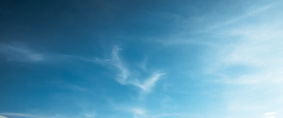 the sky is clear blue with fluffy white clouds, the sky is very bright, and the sun shines.