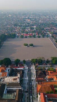 Aerial view of a alun-alun utara with vast open field contrasting with the dense urban sprawl and traditional architecture, Yogyakarta, Daerah Istimewa Yogyakarta, Indonesia.