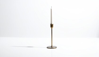 Fototapeta premium Lit taper candle sits in a slim brass holder on white