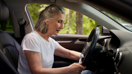 Obraz premium Angry frustrated disappointed Caucasian woman lady senior mature aged female client car driver in automobile can't start engine starting broken vehicle repair problem hit steering wheel anger annoyed