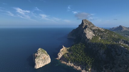 Aerial view of dramatic cliffs meeting the endless blue sea under a clear sky, a stunning landscape where the rugged coastline contrasts with the tranquil waters, Formentor, Balearic Islands, Spain.