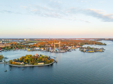 Aerial view of Djurgarden island presenting a vibrant tapestry of autumn colors meeting the tranquil blues of the surrounding waters, Stockholm, Stockholm County, Sweden.