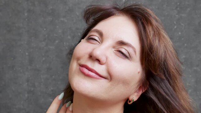 Beautiful woman 40-50 years old smiling and adjusting hair close-up gray eyes showing different joyful emotions