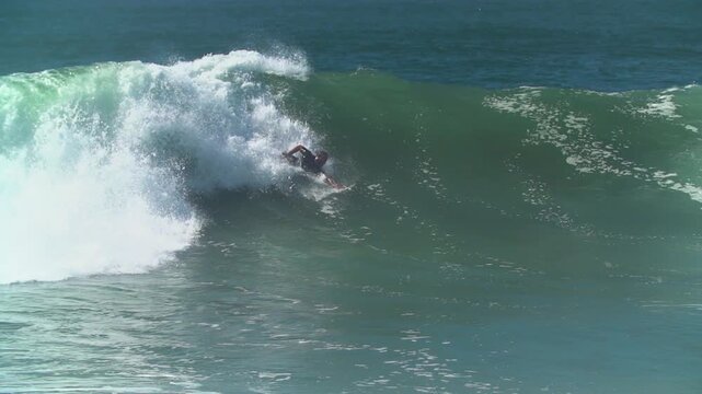 Bodysurfer riding a wave at the wedge
