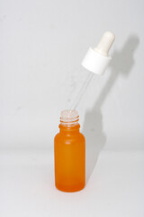 The orange minimalist skincare or essential oil container has a pipette for precise application.
