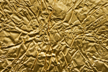 Luxury shiny metallic golden foil crumpled texture background