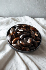 Oval platter filled with glistening dark dates on a white textured cloth