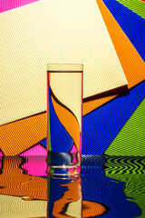 Abstract still life with a glass of water on a color bright background