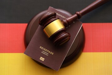 Germany passport book and judgement hammer on Germany flag close up