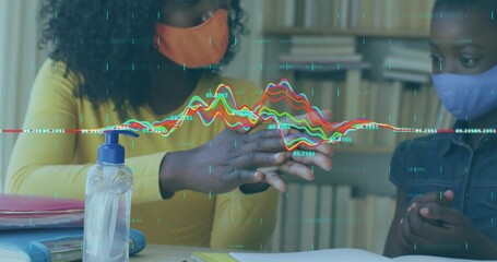 Mother and daughter wearing masks dispensing hand sanitizer at study table, with binders textbooks