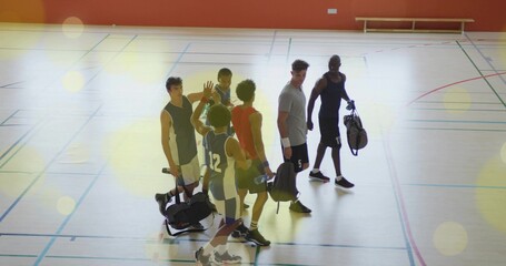 High-fiving six male basketball players leaving gym court, with duffle bags, jerseys, sneakers