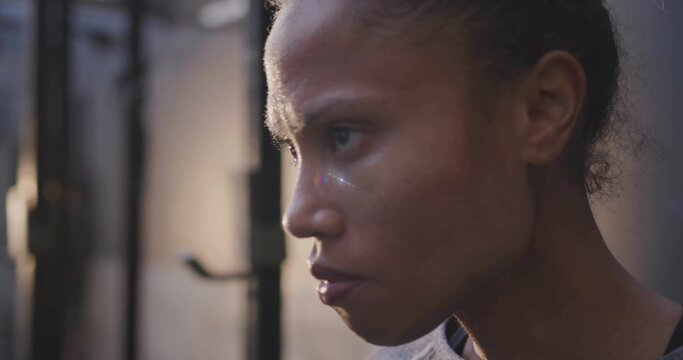 Focusing woman wearing sports top pushing through workout in gym with metal pull-up bar, copy space