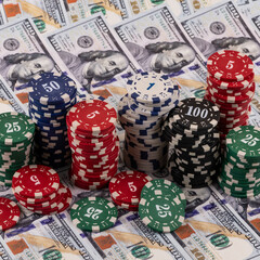 A conceptual story about ludomania (gambling addiction) with casino betting chips against a background of $100 bills.