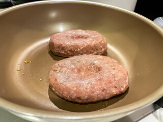 フライパンで焼いている生ハンバーグ。