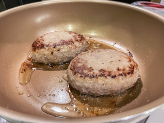 フライパンで焼いているハンバーグ。