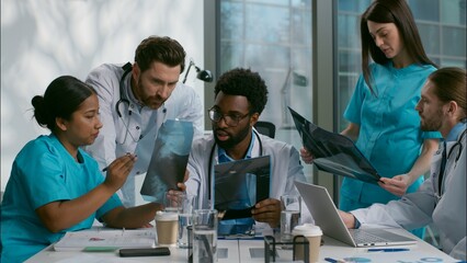 Multiethnic group doctors nurse meeting medical team talking together discuss x-ray patient results consulting each other surgery brainstorming health discussion healthcare in conference room hospital