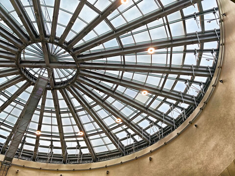 Unique architectural design of a circular glass ceiling with modern lighting fixtures in an indoor space