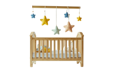 Wooden baby crib with a polka-dot sheet, stuffed toys and a hanging star mobile.