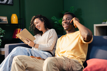 Diverse couple relaxing at home enjoying leisure time