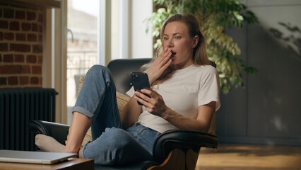Shocked worried woman browsing smartphone shock reading bad news problem at home anxious frustrated...