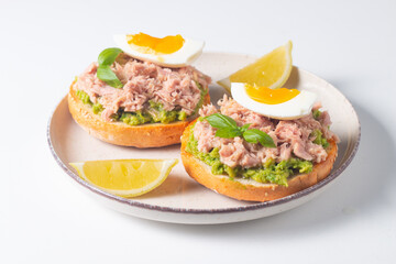 Two delicious tuna open sandwiches with avocado and boiled eggs. Tuna toast.