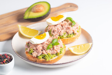 Two delicious tuna open sandwiches with avocado and boiled eggs. Tuna toast.