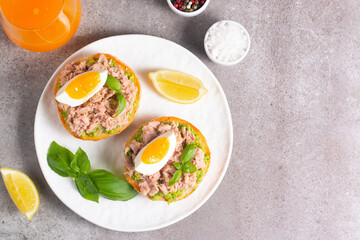 Two delicious tuna open sandwiches with avocado and boiled eggs. Tuna toast.