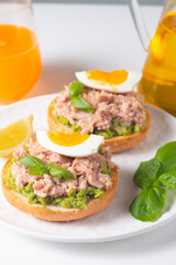 Two delicious tuna open sandwiches with avocado and boiled eggs. Tuna toast.