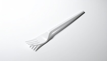 White plastic fork casts simple shadow on a white surface
