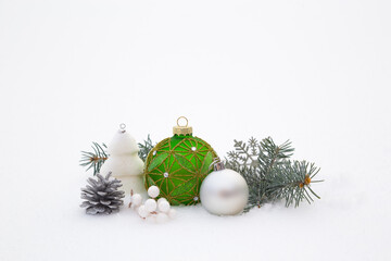 Christmas decorations and fir branches in fluffy snow. Copy space