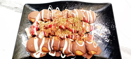 A tasty pancake with chocolate and fresh strawberries slices