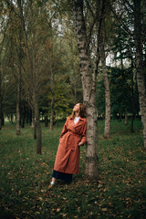 Fototapeta premium A girl in a cloak near a tree