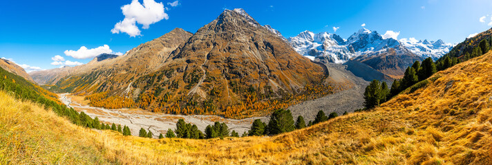 Autumnal view of the Roseg Valley, Switzerland, with trees and autumn colors.
