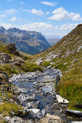 Mountain stream flows through rocky alpine landscape